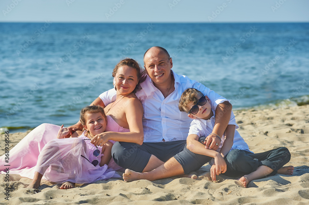 Family on the sea coast . Happy married couple with children on their wedding anniversary day in their wedding dresses . The concept of a happy marriage