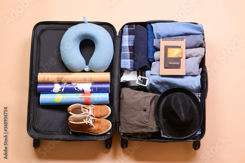 Packed suitcase on color ba...