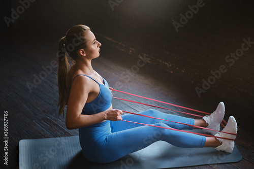 Crossfit healthy concept. Woman wearing sport clothing using resistance band