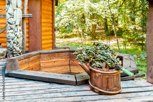 Bath and sauna. Wooden bathhouse with bucket and broom. Traditional hygiene. Outdoor
