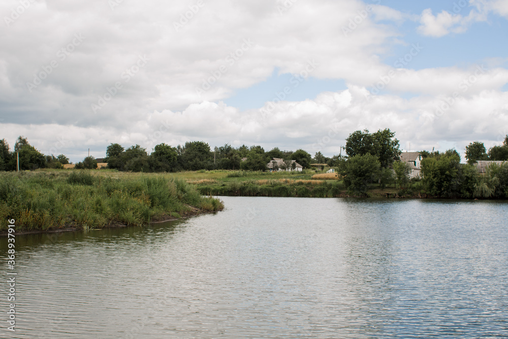 Fototapeta premium small lake in a village in a meadow