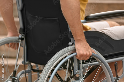 Young man in wheelchair outdoors, closeup