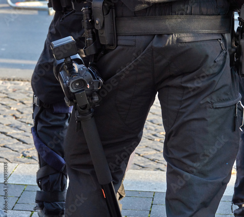 Belt of a German policeman in black uniform with a camcorder to preserve evidence by video recording