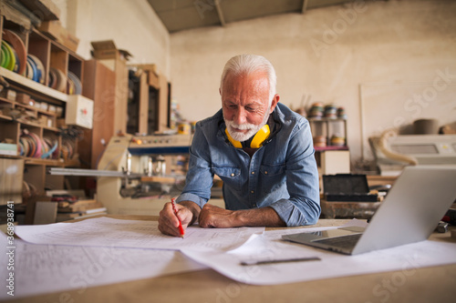 Senior architect working on blueprints