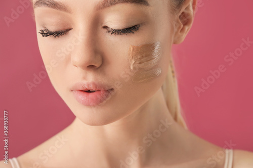 Valokuva Beautiful young woman with foundation on her face against color background