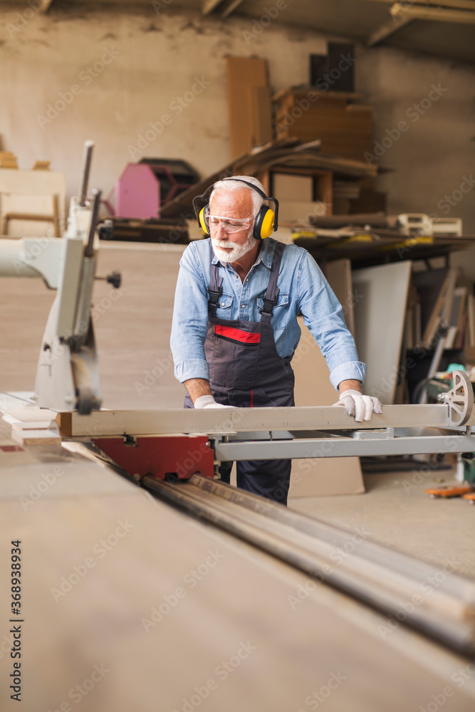 Elderly carpenter using circular saw Elderly carpenter using circular saw