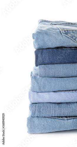 Stack of jeans pants on white background