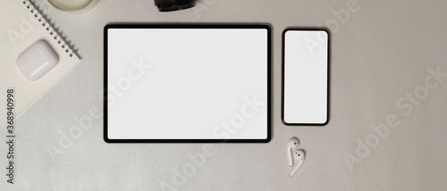 Digital tablet and smartphone with accessories on white table, clipping path.