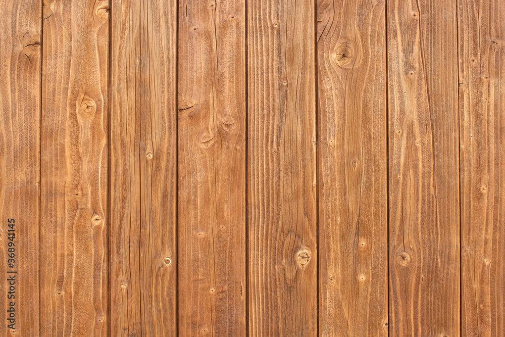 The wooden fence is brown in color with a distinct texture. The wooden fence is brown in color with a distinct texture.