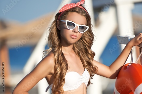 Beautiful  girl  in white clothing relaxing at the sea beach. Summertime.