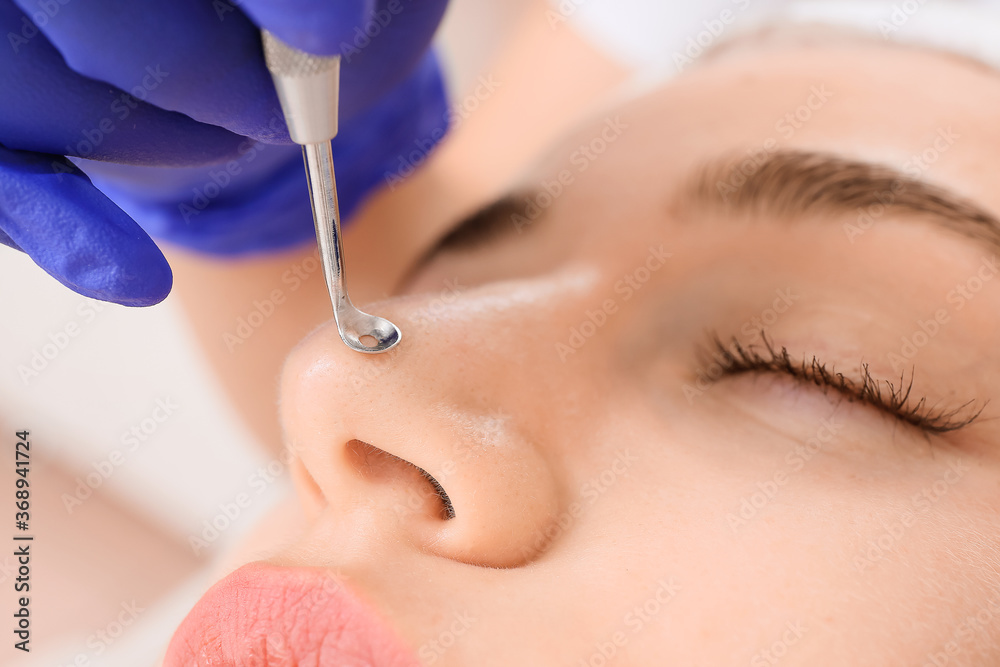 Woman undergoing procedure of facial peeling in beauty salon, closeup