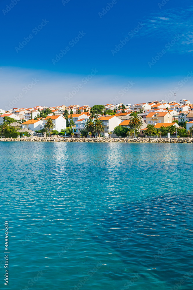 Croatia, touristic town of Novalja on the island of Pag, turquoise sea in foreground