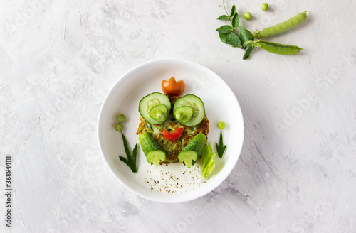 Creative idea for a kids breakfast, frog made from vegetable cutlets. food art idea. Children, holidays, summer, holidays, 
Easter, healthy, proper nutrition concept. Free space for text. Baby food.  photo