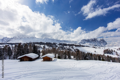 A house in the mountains, a wide panorama of the snow cover of the mountain peaks. Spring Sunny day in the Alpine mountains with clear sky and pure white snow