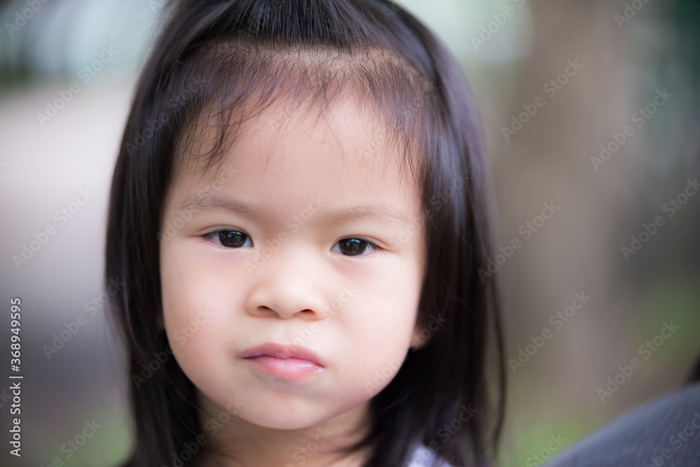 Closeup cute little Asian girl pocketing food in her mouth causing tooth decay. child girl with rice filled her cheeks. Children is 3 years old. Closeup cute little Asian girl pocketing food in her mouth causing tooth decay. child girl with rice filled her cheeks. Children is 3 years old.