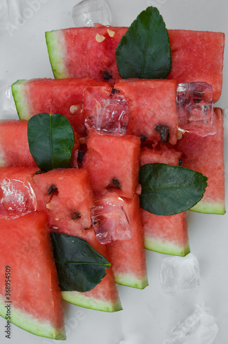 Fresh watermelon sliced into pieces on white background