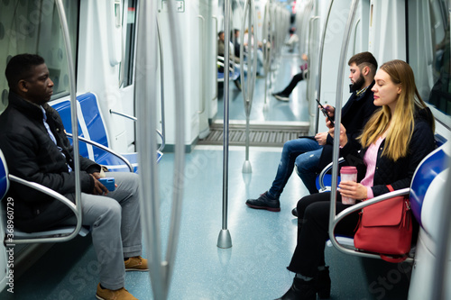 Portrait of casual people wearing warm jackets riding subway on way to work on winter day photo