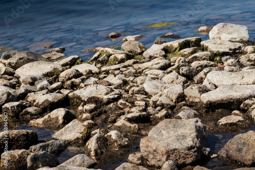 The rocky shore of the lake in the afternoon.