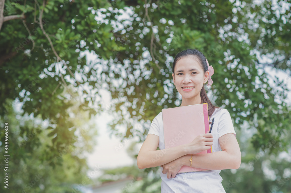 Asian women holding book standing outdoor concept,Back to school Asian women holding book standing outdoor concept,Back to school