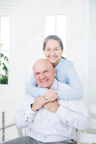 Elderly woman embracing mature man.
