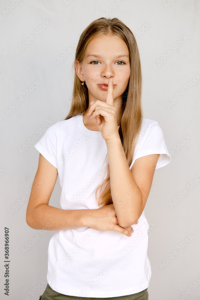Portrait of teenager girl holding finger near lips Portrait of teenager girl holding finger near lips