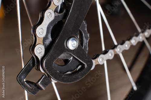 Gearshift on mountain bike MTB, chain moves on rings. Changes speeds. Shift gears on bicycle crank. Work of chain drive chainset. Front derailleur. Macro closeup low angle shot. Wheel spins and turns