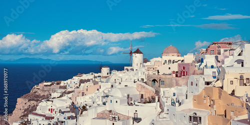 Clouds fly over windmill in Oia village on Santorini, Greece