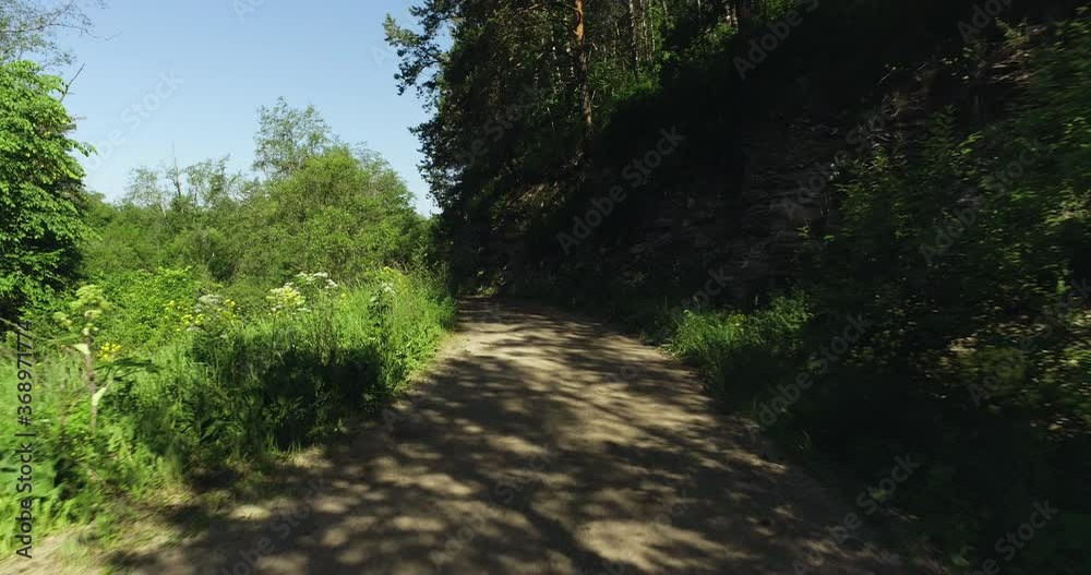 Gravel rocky road with high grass in mountain landscape / difficult way wild nature. Dolly wide mid shot at summer sunny day. Gravel rocky road with high grass in mountain landscape / difficult way wild nature. Dolly wide mid shot at summer sunny day.