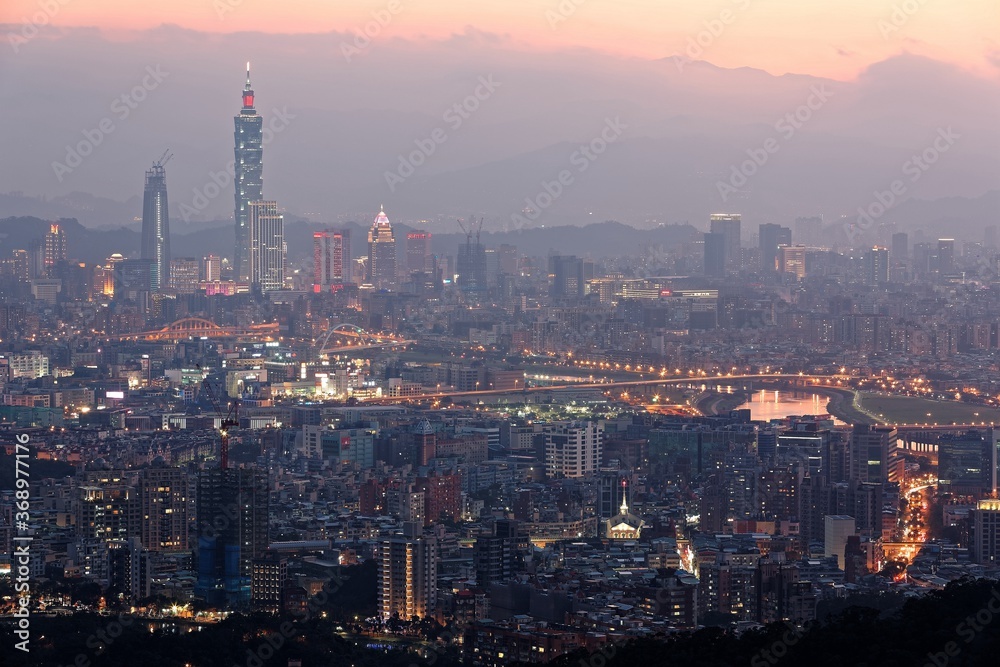 Aerial panorama of Downtown Taipei at night with view of bridges over Keelung River & Taipei 101 Tower amid skyscrapers in Xinyi Financial District~ Romantic nightscape of a busy city in a gloomy mood