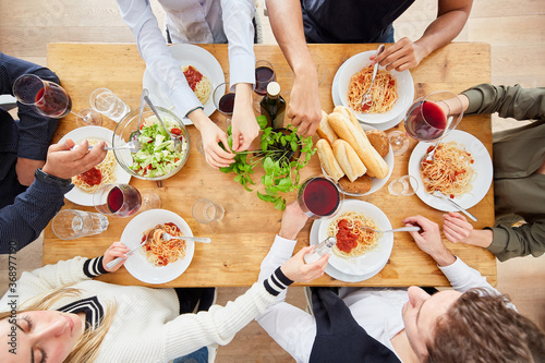 Group of friends having pasta meal together from above