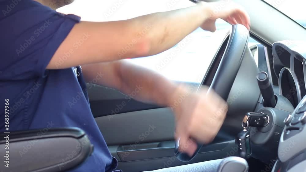 Caucasian man in blue short sleeve shirt drives a car and turns the steering wheel close-up. High quality FullHD footage Caucasian man in blue short sleeve shirt drives a car and turns the steering wheel close-up. High quality FullHD footage
