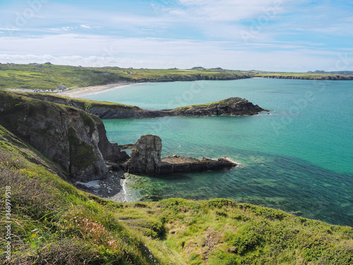 View from the coastal path around at St Davids Peninsula over the sandy beach of Whitesands Bay and dramatic cliffs and coves, Pembrokeshire Coast National Park, Wales, UK photo