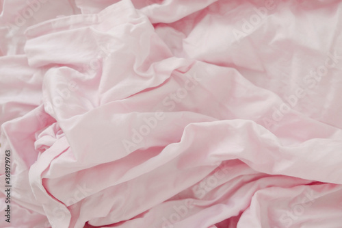 Crumpled pastel pink bed linen for light background.