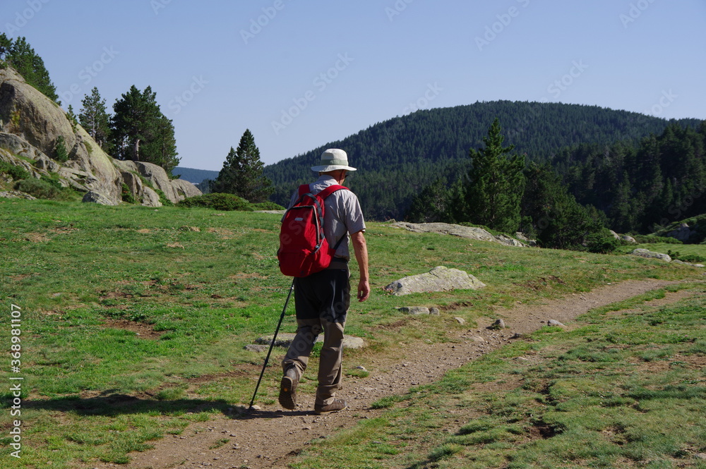 Randonneur en montagne sur sentier qui marche avec sac à dos dans les Pyrénées