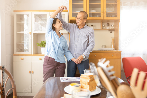 a couple elder or a retired older man and woman happy cooking with breakfast in the morning, holiday family relaxing in the kitchen, lovely grandparent resting or dancing