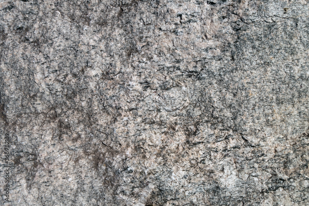 Close up view onto rough texture of granite's surface & its grained structure