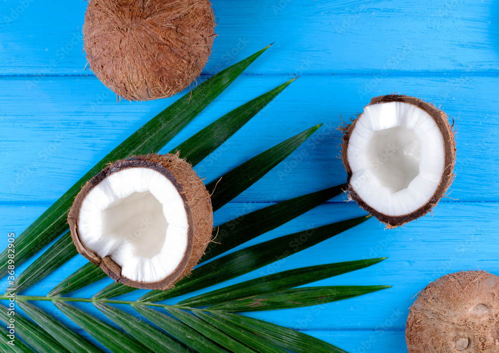 Coconuts with palm leaves on wooden table Coconuts with palm leaves on wooden table
