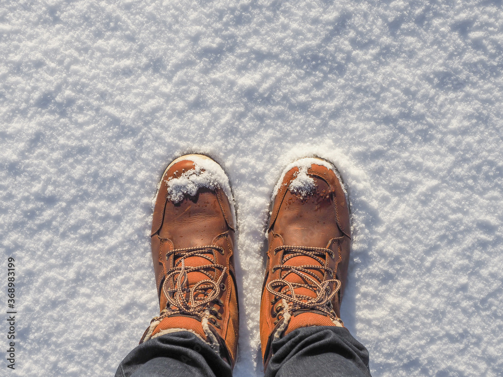 Top view of shoes / boots in fresh snow. Winter season. Top view of shoes / boots in fresh snow. Winter season.