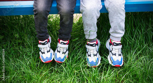Принти на полотні childs sitting together in the same sneakers