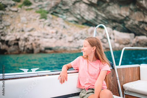Little girl sailing on boat in clear open sea photo