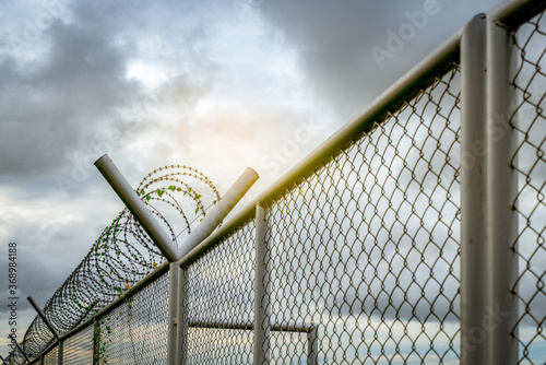 Prison security fence. Barbed wire security fence. Razor wire jail fence. Barrier border. Boundary security wall. Prison for arrest criminals or terrorists. Private area. Military zone concept.