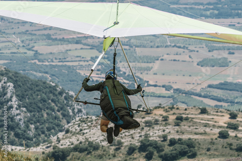 A hang glider takes off on a mountain