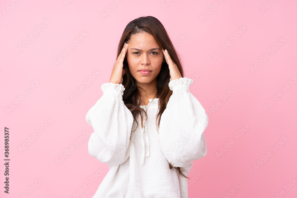Young Brazilian girl over isolated pink background with headache Young Brazilian girl over isolated pink background with headache