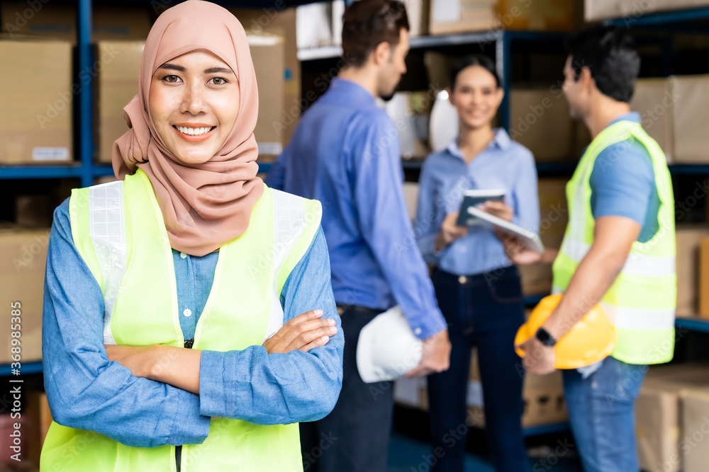 Islam Muslim female warehouse worker portrait with her team
