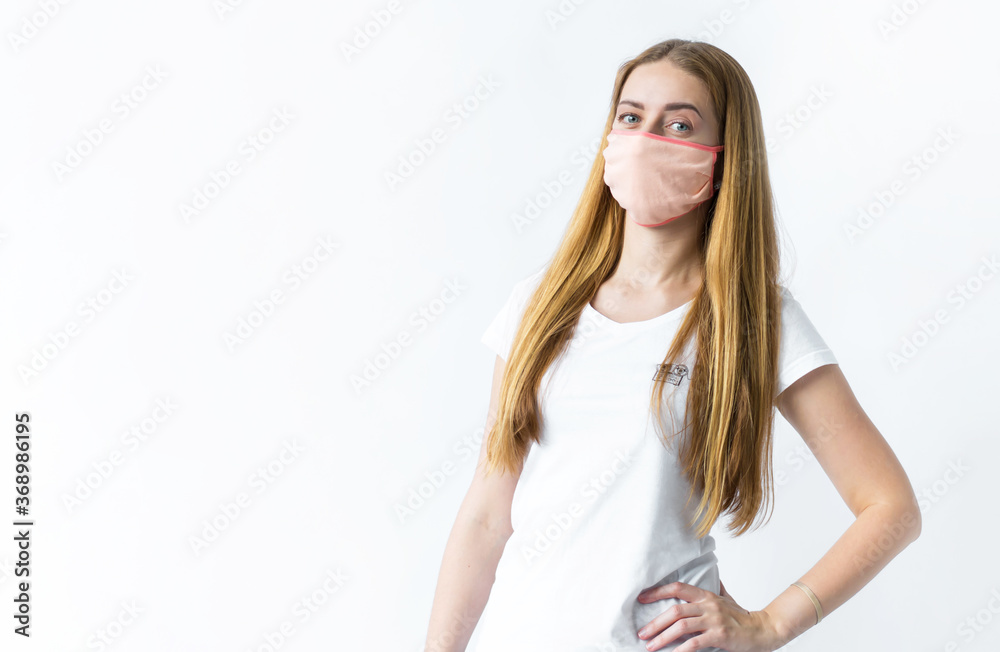 A young girl in a mask from a virus stands on a white background. Coronavirus and security theme