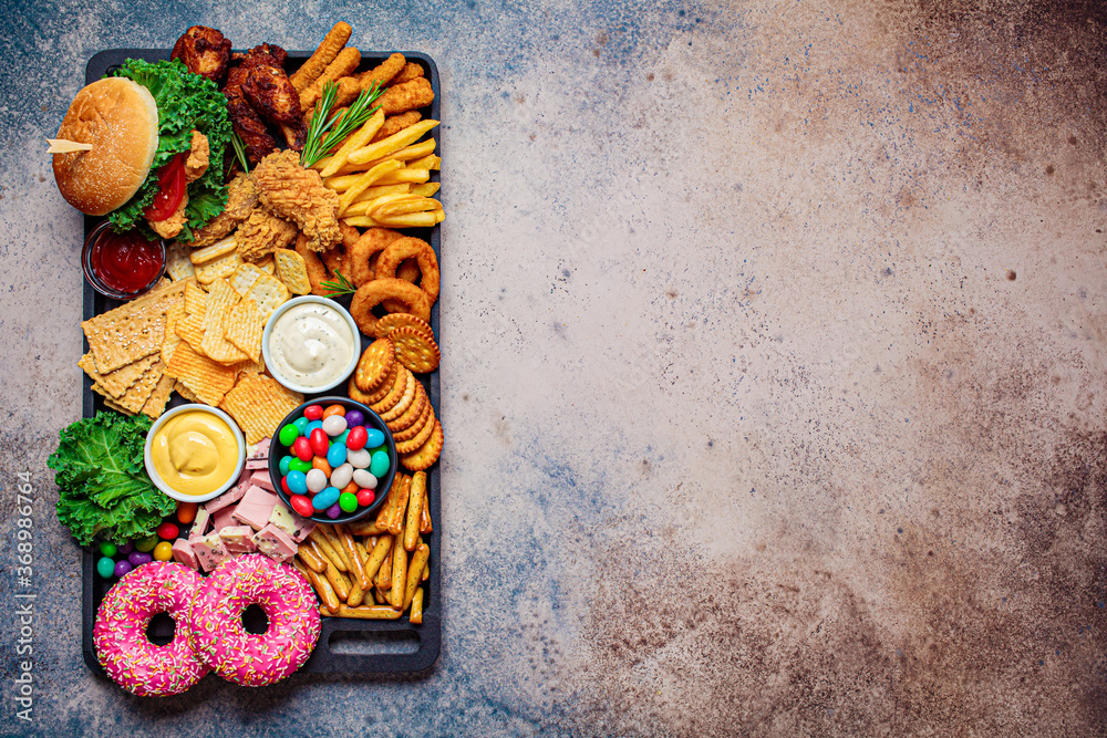 Fast food platter. Junk food concept. Unhealthy food for the heart, teeth,  skin, figure, top view. Stock Photo | Adobe Stock