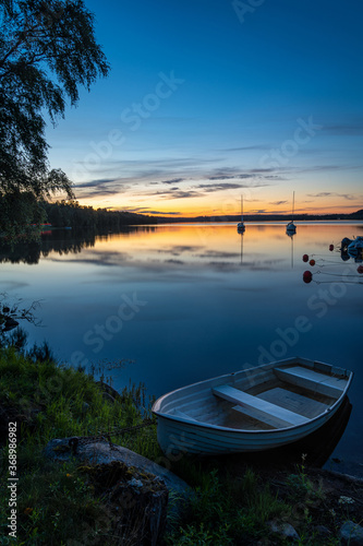 Long exposure image of boat on the calm lake during sunset or sunrise