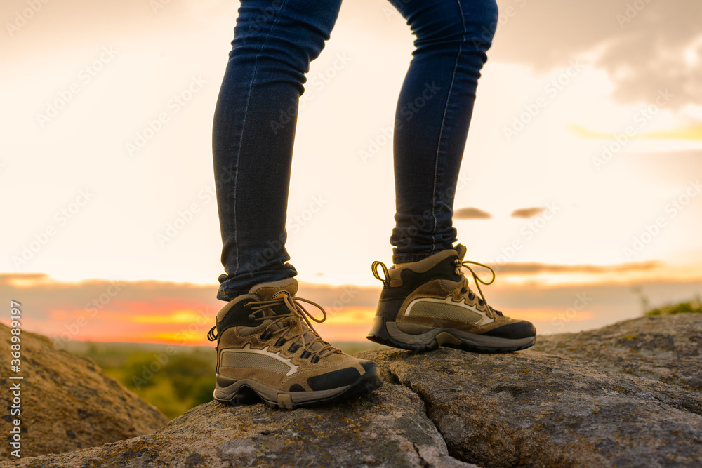 Hiker's Legs on the Rocky Trail at Summer Sunset. Travel and Adventure Concept.