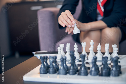 Foto Businesswoman sitting in armchair and playing chess
