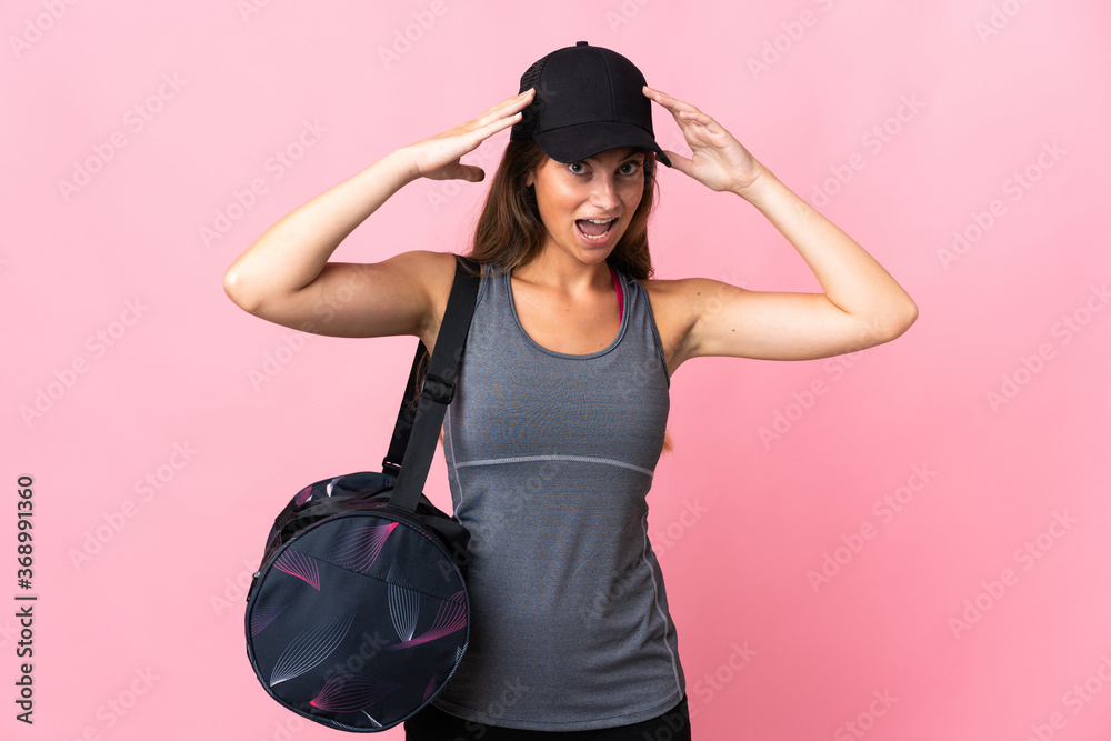 Young sport woman with sport bag isolated on pink background with surprise expression